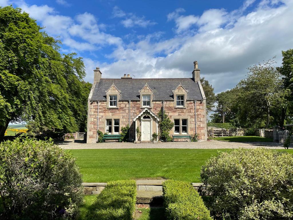 an old stone house with a green lawn at Balloan House-Uk7383 in Dornoch