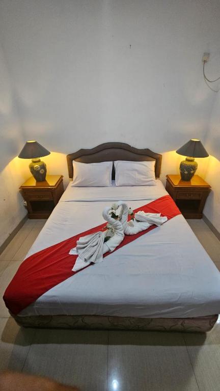 a large bed with clothes on it in a bedroom at Dekuningan Executive in Jakarta
