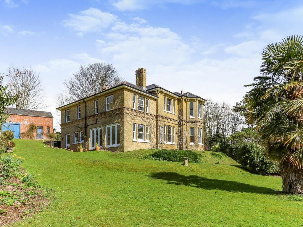 an old brick house on a grassy hill at Downedge in Brading