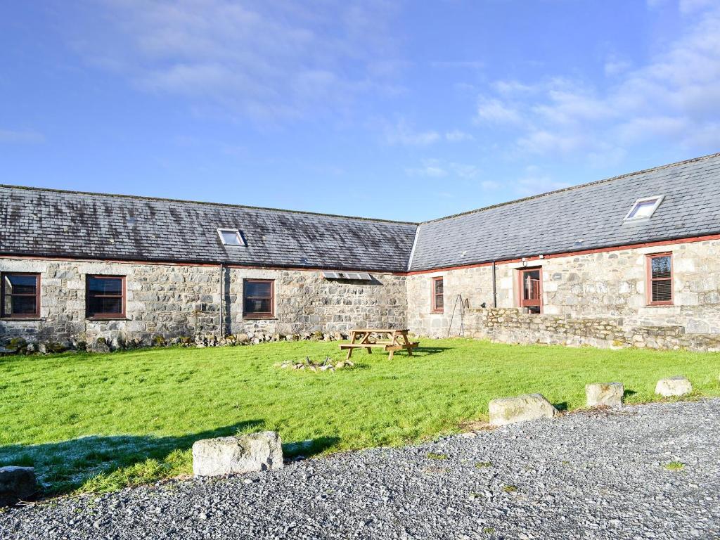 a stone building with a picnic table in front of it at Anne's Cottage - Uk7782 in Newton Stewart