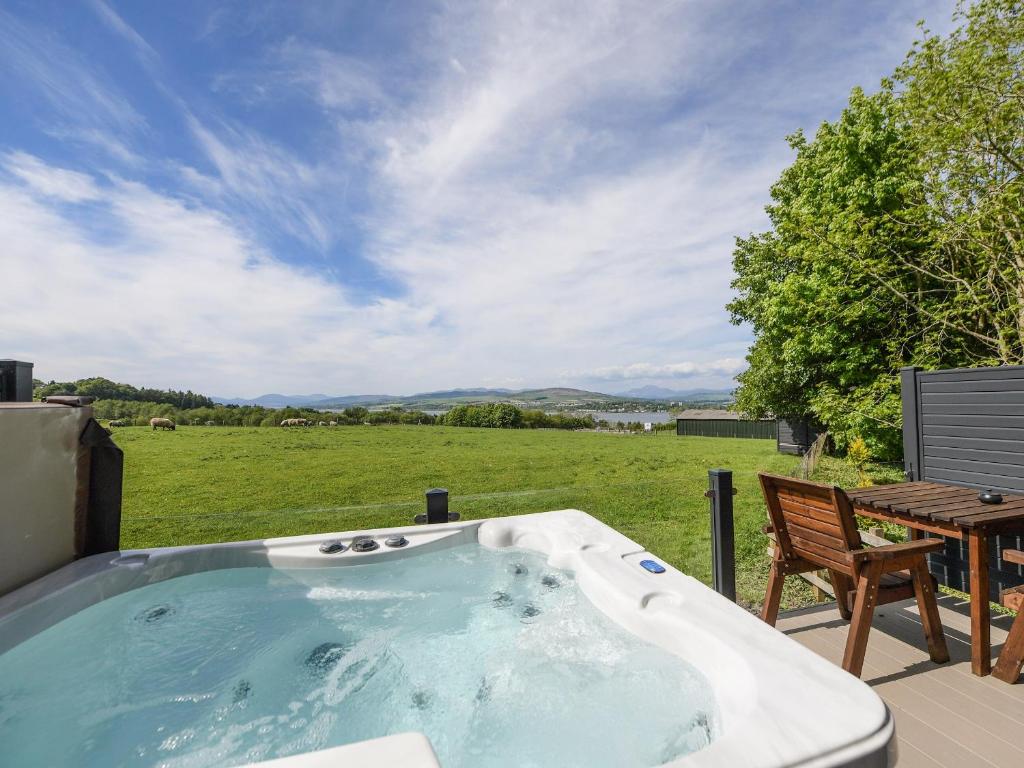 a jacuzzi tub with a table and a chair at Clyde View in Langbank