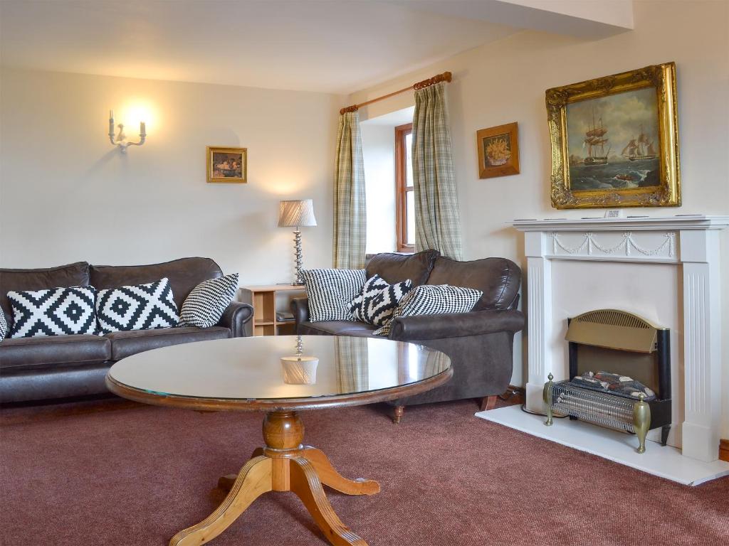 a living room with couches and a table and a fireplace at The Walton - Ukc3232 in Onibury