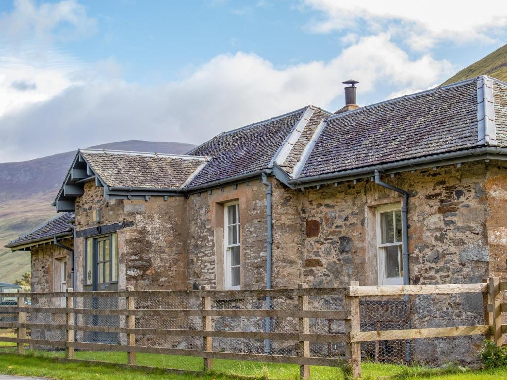 an old stone house with a wooden fence at Marble Lodge - Uk7635 in Pitlochry