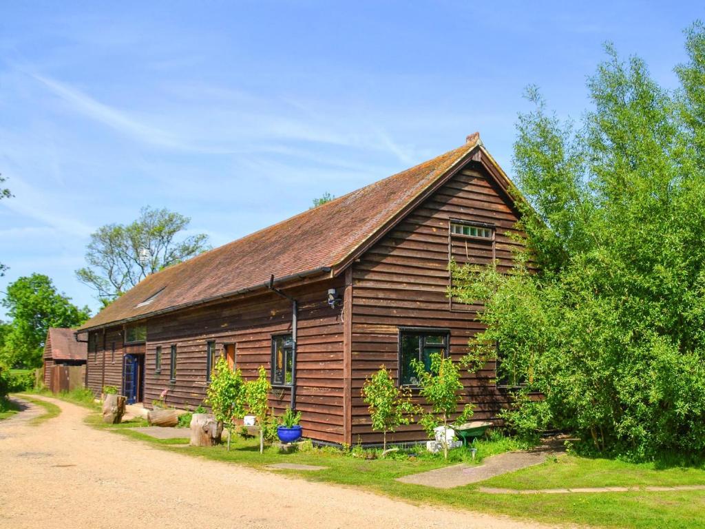 a wooden house with a roof on a dirt road at The Timber Store in Hardham