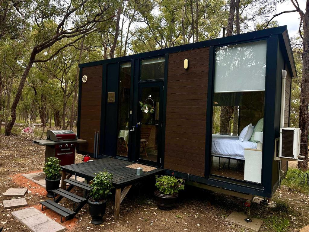 a tiny house in the woods with a bedroom at Gum Tree Hideaway by Tiny Away in Stoneville