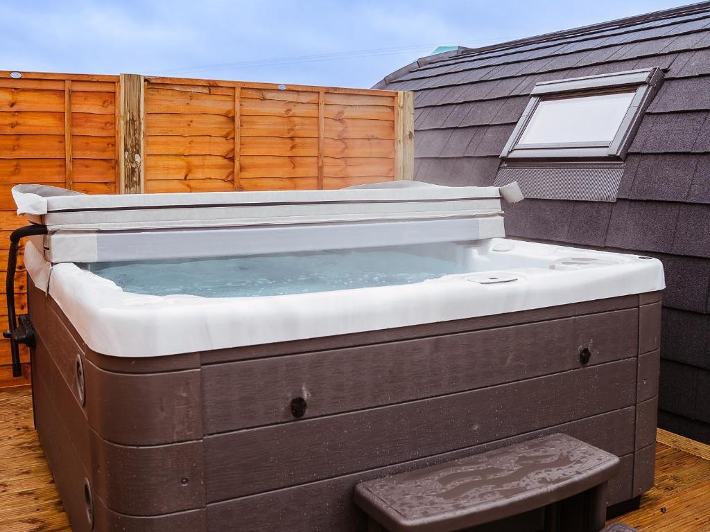 a hot tub sitting on top of a patio at Oak-Uk7587 in Stewarton
