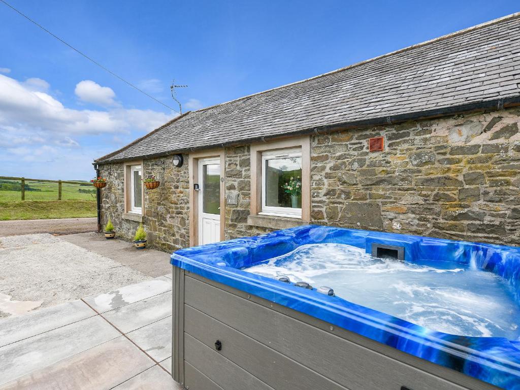 a large blue tub in front of a stone house at The Byre in Kirkcudbright