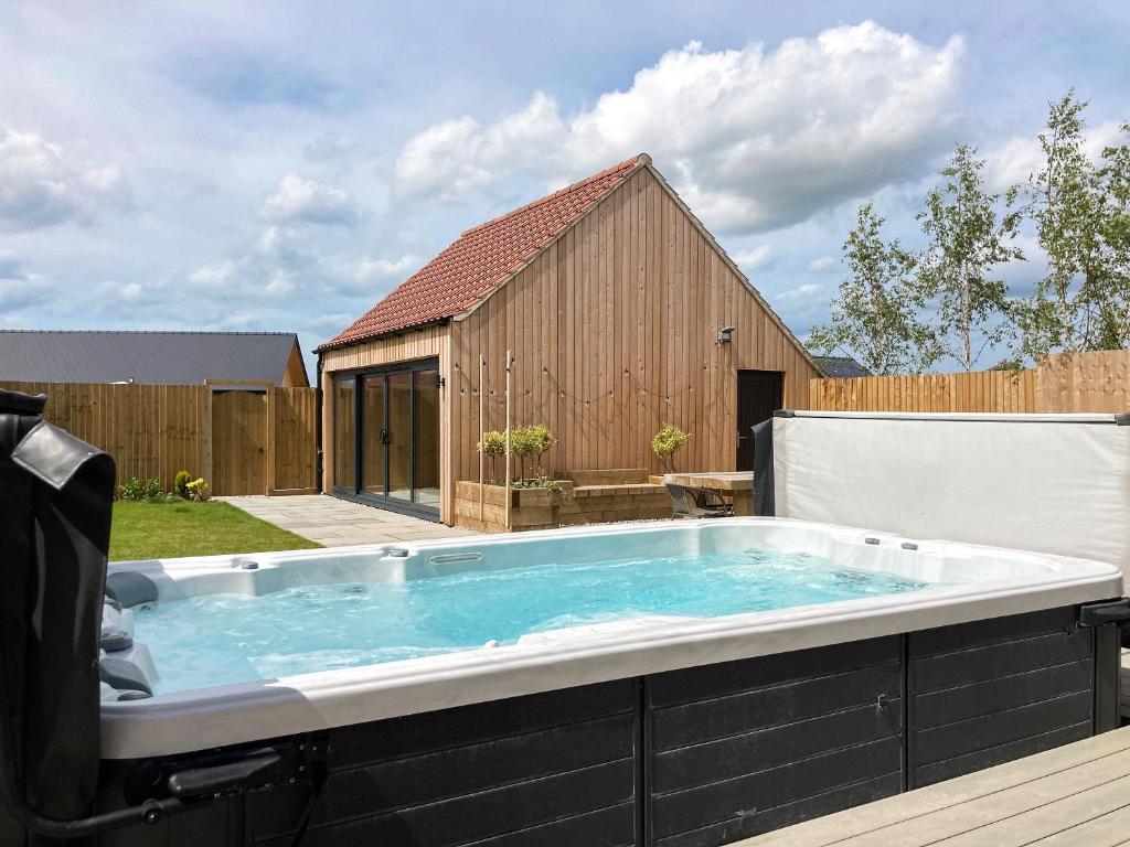 a hot tub in a backyard with a building at The Pines - Ukc4615 in Dunholme