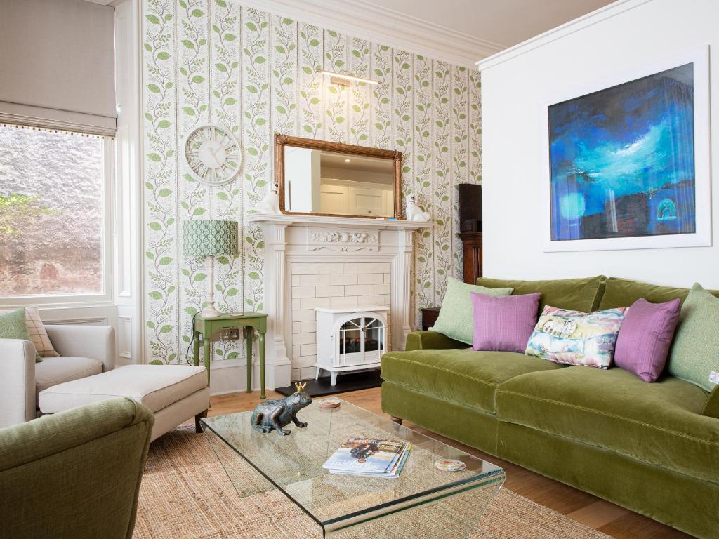 a living room with a green couch and a fireplace at But N' Ben - Uk7560 in Inverness