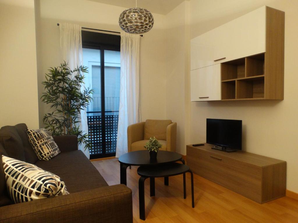 sala de estar con sofá y mesa en Málaga Apartamentos - Jinetes, 14, en Málaga