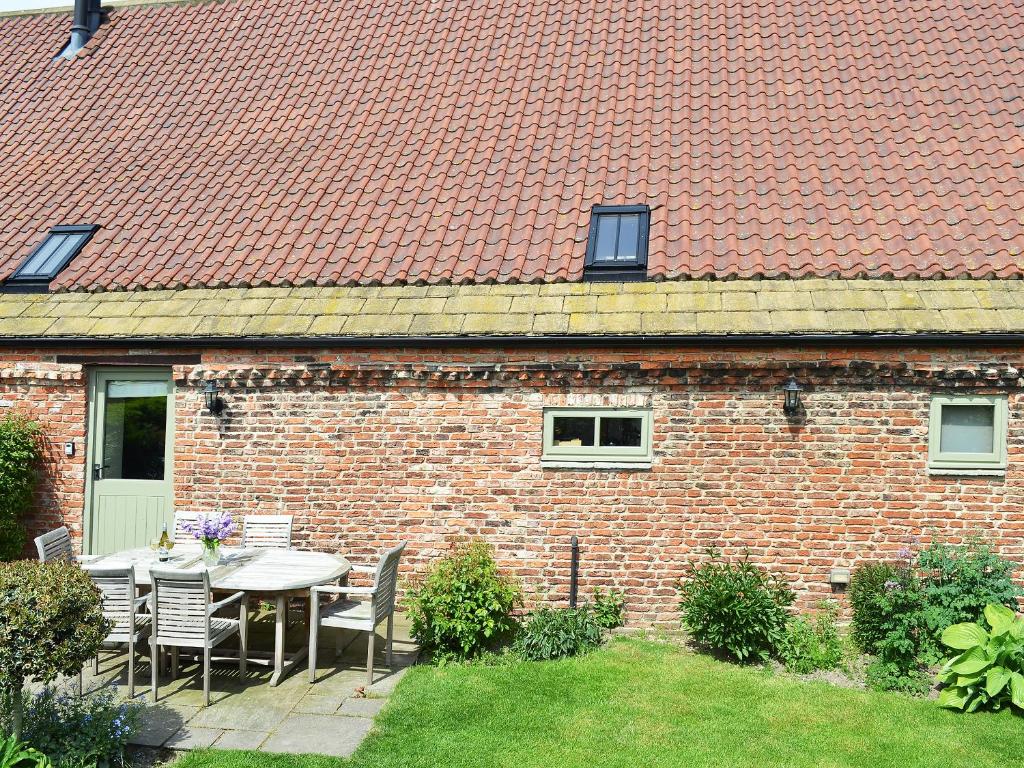 a brick house with a table and chairs in the yard at The Hayloft-W42941 in Burn