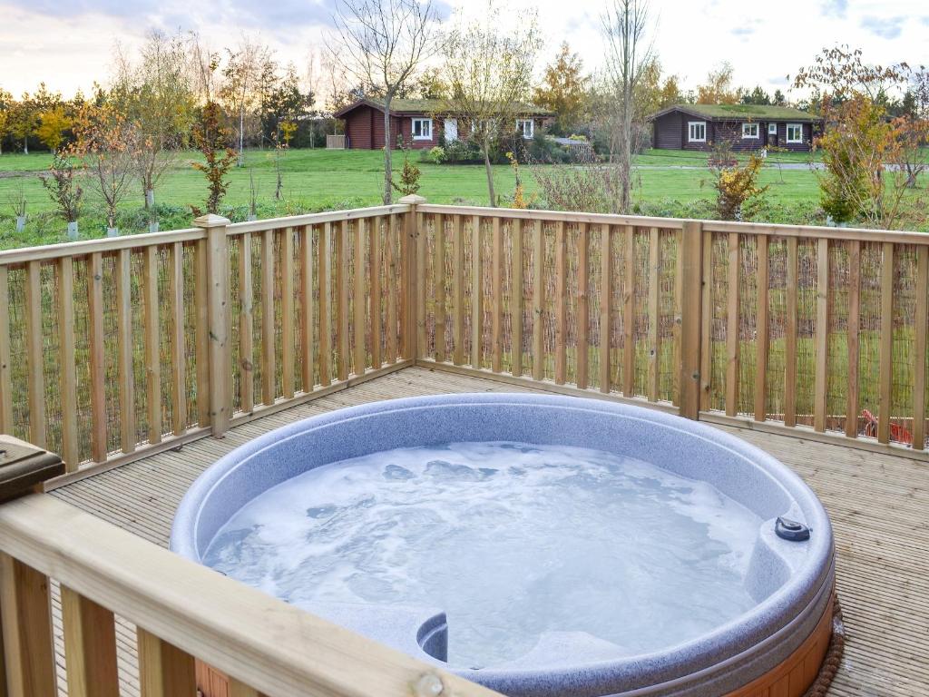 a hot tub on a deck with a fence at Teal Lodge- Ukc2565 in Burn