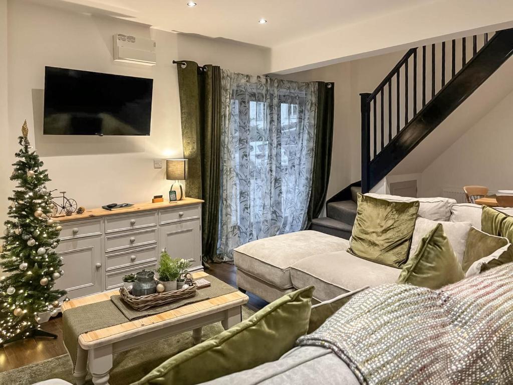 a living room with a christmas tree and a couch at Coachmans Cottage in Settle