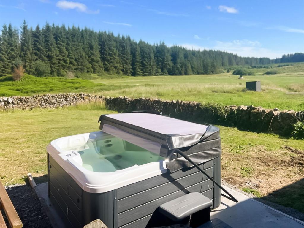 a hot tub sitting on a table in a field at Merrick Cottage - Uk7783 in Newton Stewart
