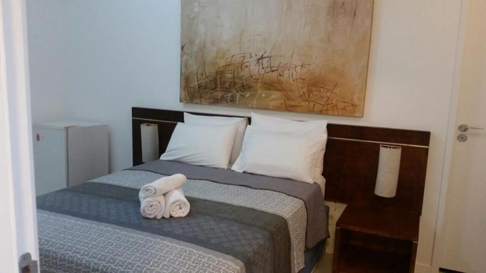 a bedroom with a bed with two towels on it at Flat Villa Del Sol-Praia da Macumba in Rio de Janeiro