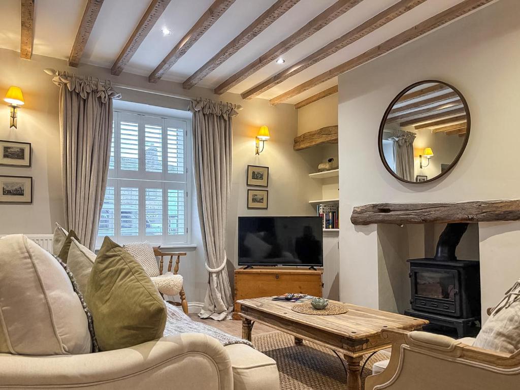 a living room with a couch and a mirror at Bailey Cottage in Skipton