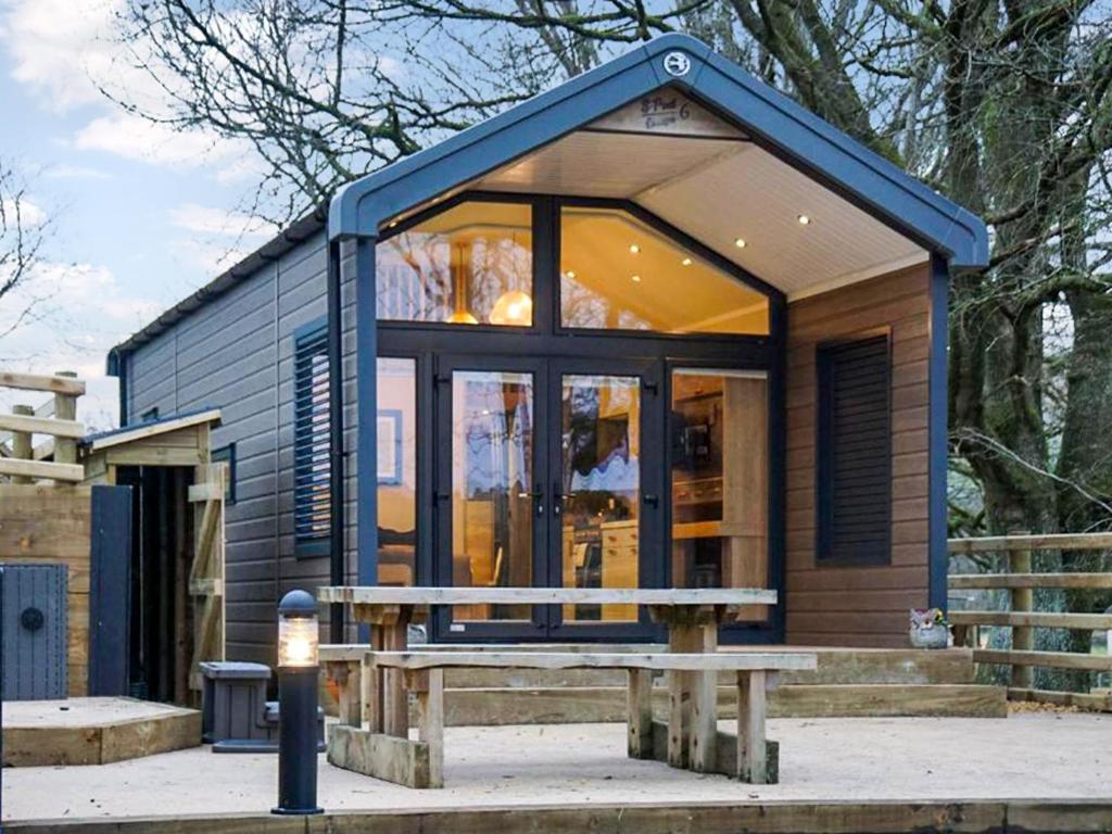 a tiny house with a bench in front of it at Woodland Escape - Ukc8186 in Dolau