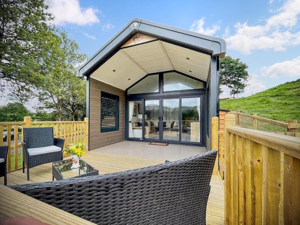 a small house with a roof on a wooden deck at Meadow Retreat - Ukc8192 in Dolau
