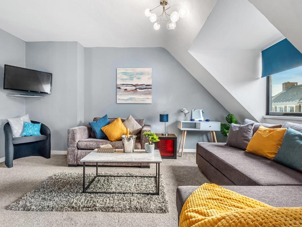 a living room with a couch and a table at Sandyford Apartment in Jesmond