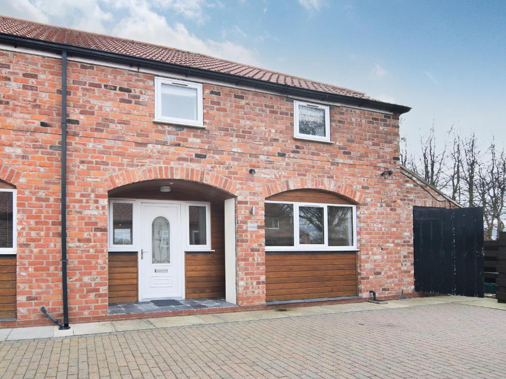 a brick building with a white door and two windows at Cottage 8 - Ukc3185 in York