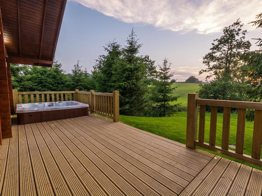 a large wooden deck with a hot tub on it at Henning Lodge - Uk31008 in Ansty