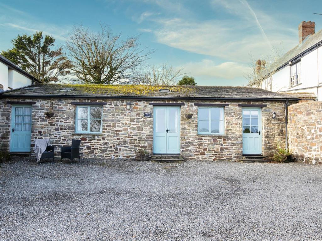 a brick house with two blue doors and two chairs at Lavender Cottage - Ukc4695 in Kilkhampton