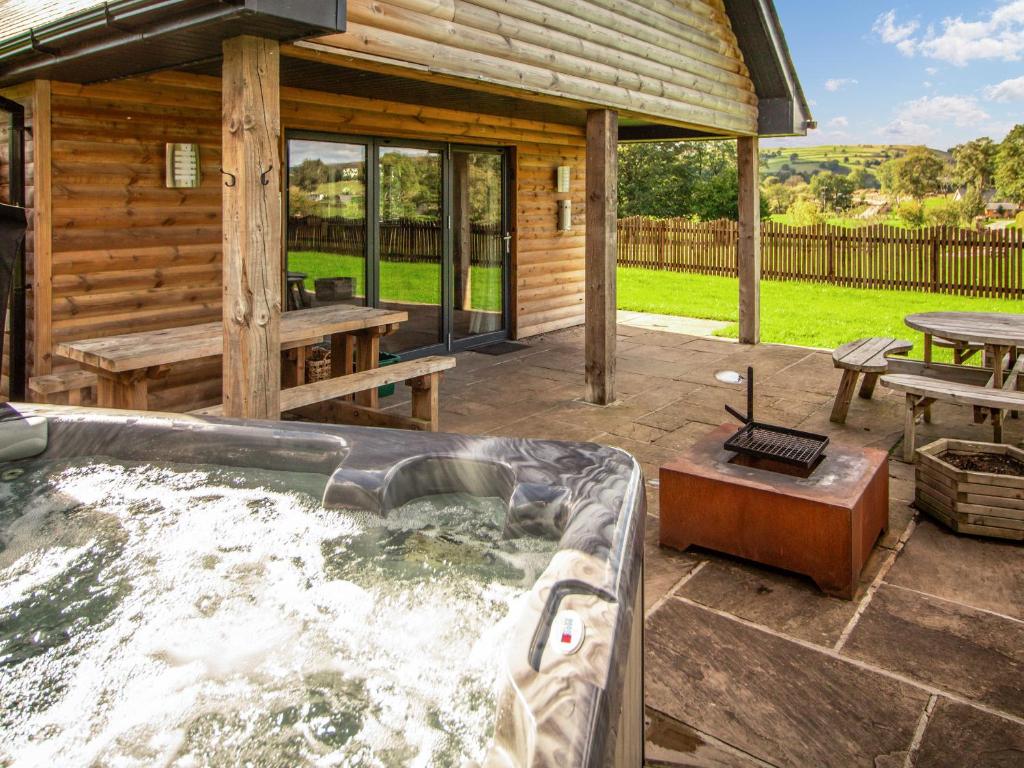 a hot tub in front of a log cabin at Caban Dulas - Ukc8195 in Dolau