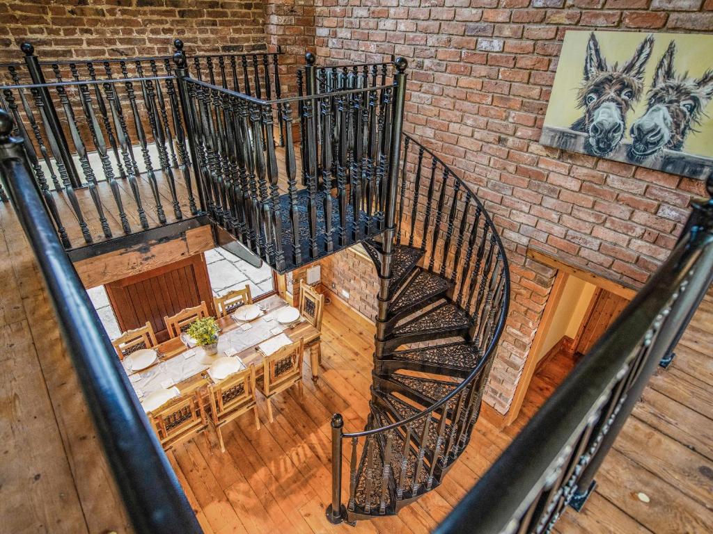 an overhead view of a spiral staircase with a table at The Threshing Barn - Ukc8847 in Timberland