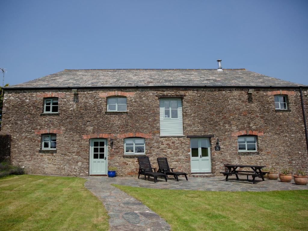 a brick building with two chairs and a picnic table at Rose Cottage - Ukc4693 in Kilkhampton
