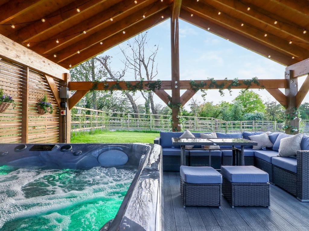 a patio with a jacuzzi tub in a backyard at 15 Chivits - Ukc8971 in Warkworth