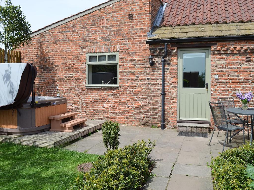 a brick building with a patio with a grill and a table at The Forge-W42942 in Burn
