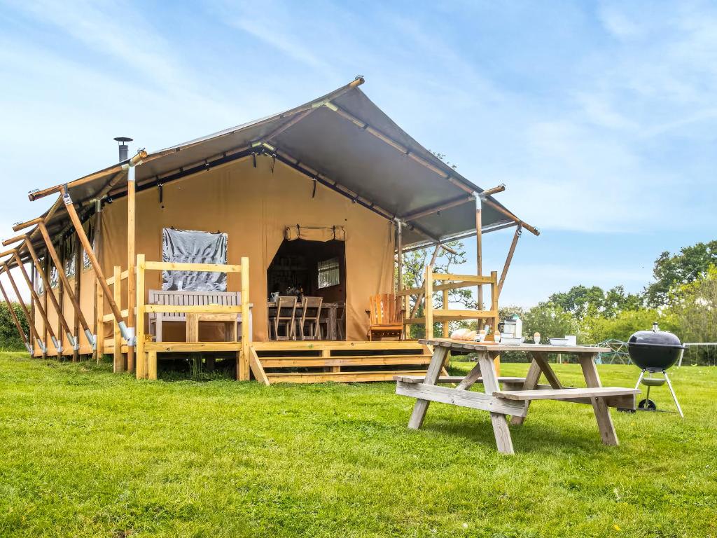 a tent with a picnic table and a grill at Swallow - Safari Tent - Ukc8985 in Romsey