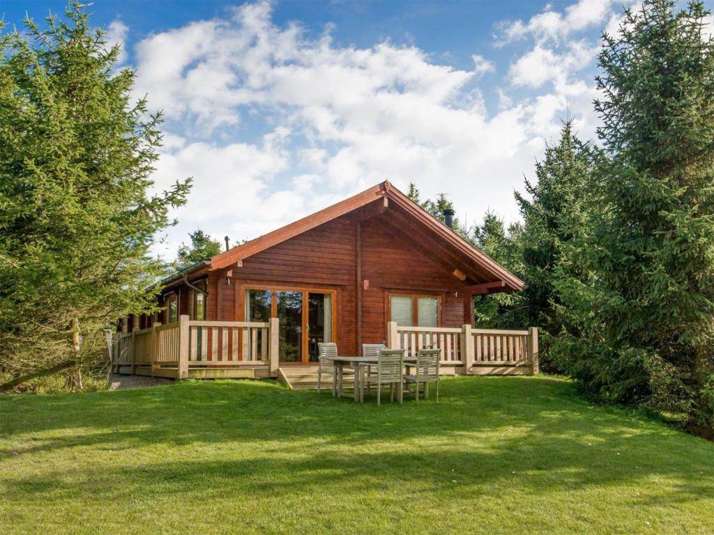a log cabin with a table and chairs in the yard at Rawlsbury Lodge - Uk31007 in Ansty