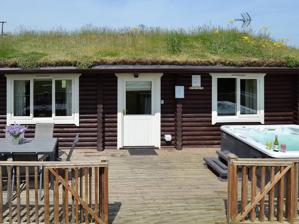 a cabin with a hot tub and a grass roof at Mallard Lodge - W43171 in Burn