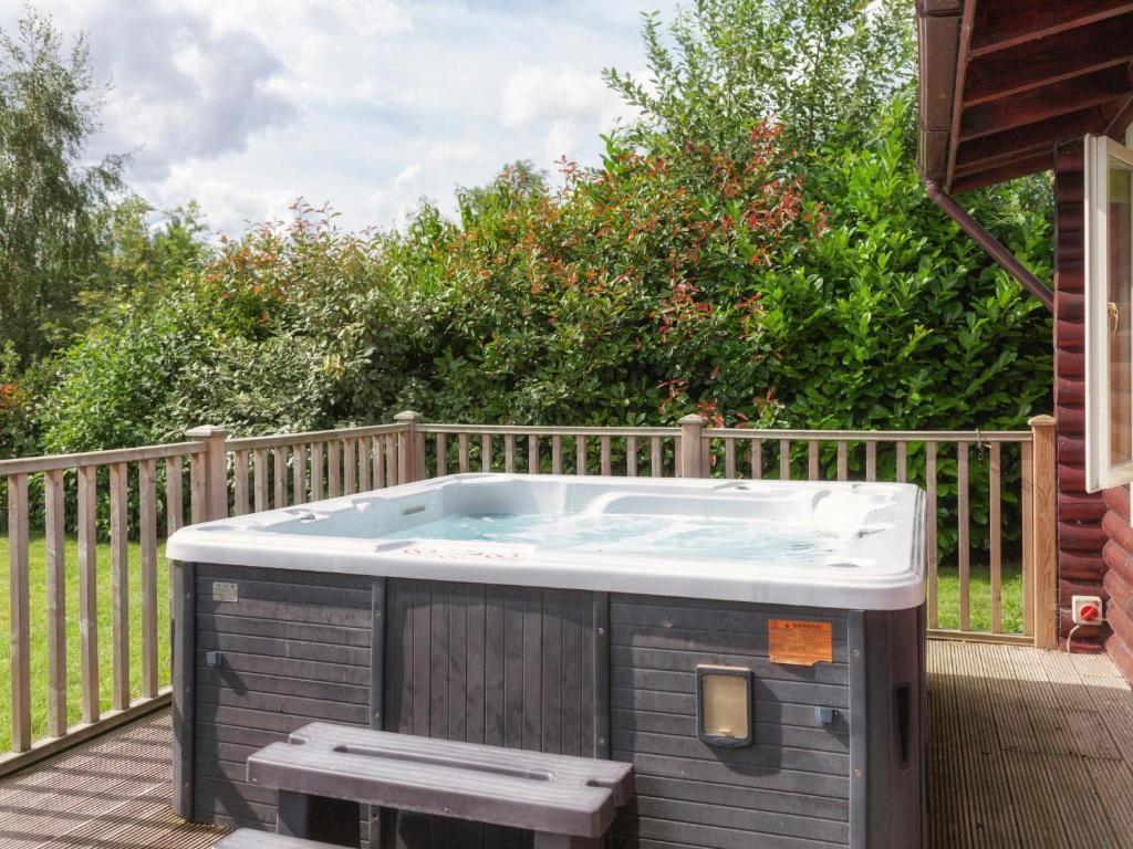 a hot tub on the deck of a house at Partridge Lodge-W43008 in Burn