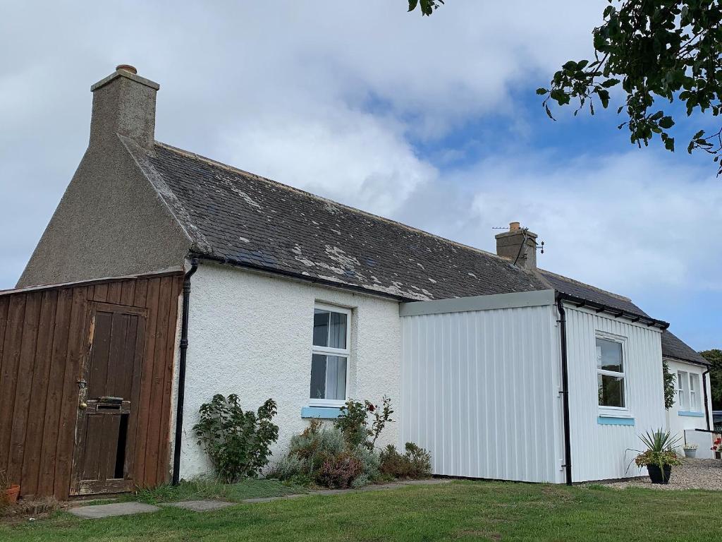a white house with a brown roof at Ploughmans Cottage-Uk7346 in Dyke