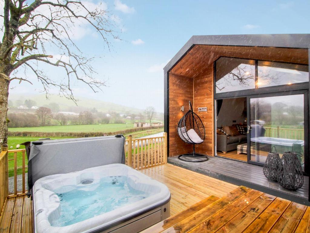 a large hot tub on a deck with a view at Buck Barn - Ukc8185 in Dolau