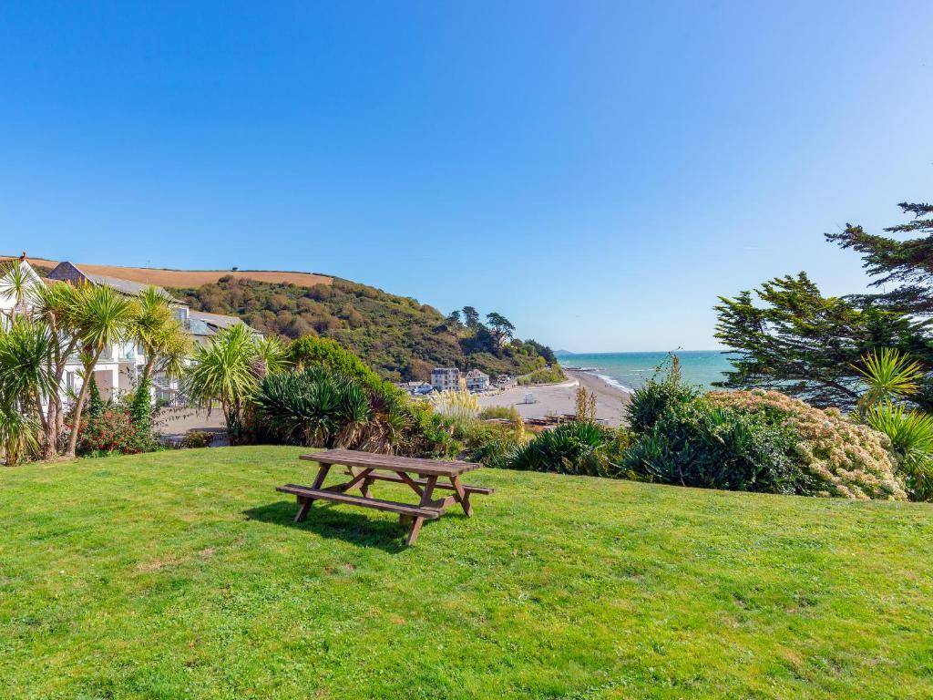 a wooden bench sitting in the grass near the ocean at 17 Mount Brioni in Downderry