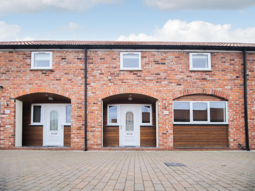 an empty brick building with two white doors at Cottage 7 - Ukc3184 in York