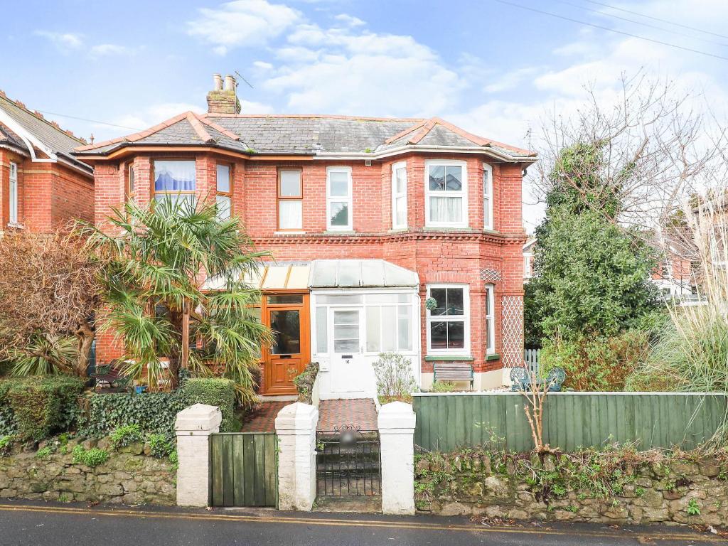 a brick house with a fence in front of it at Kenmare Cottage in Shanklin