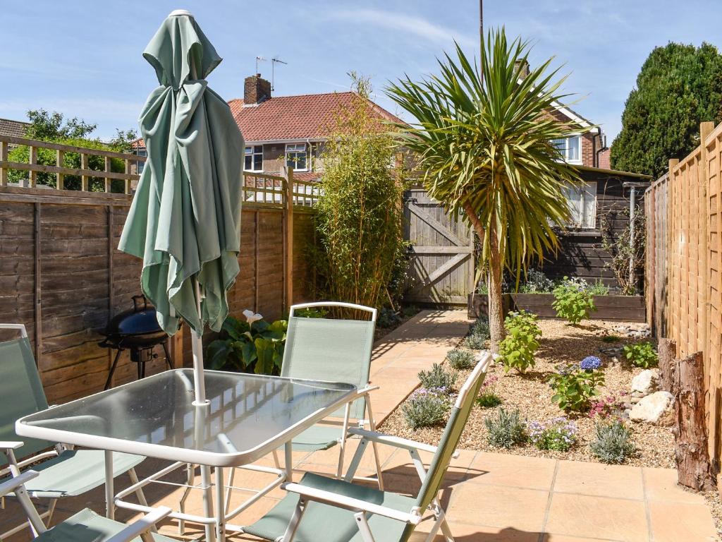a patio with a glass table and chairs at Curlew Cottage- Ukc5450 in Pakefield