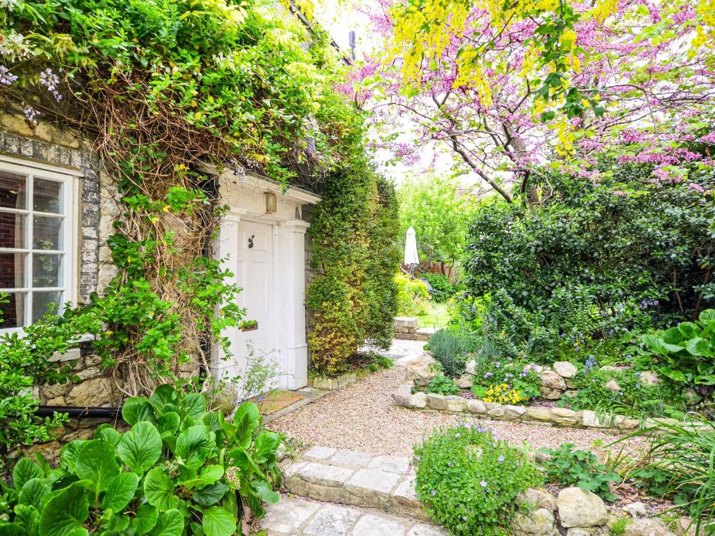 a garden with a white door in a building at Grove Cottage in Yarmouth