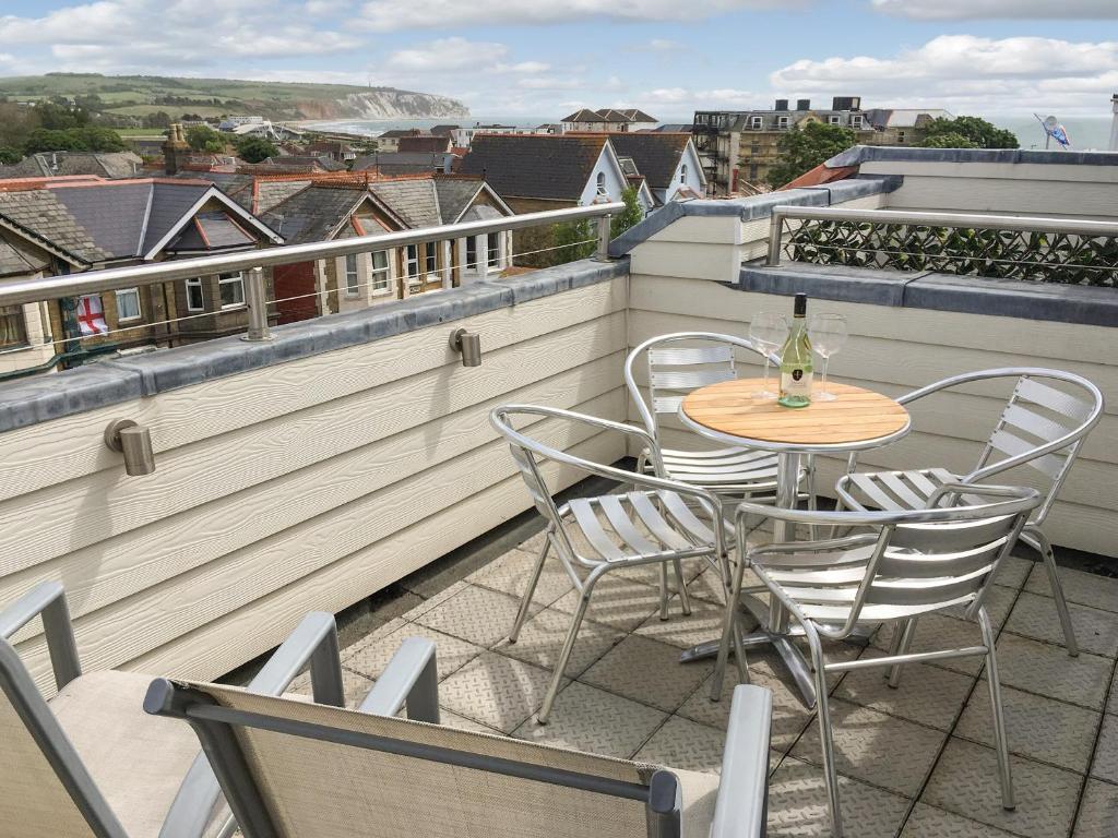 a patio with a table and chairs on a balcony at The Sanctuary in Sandown