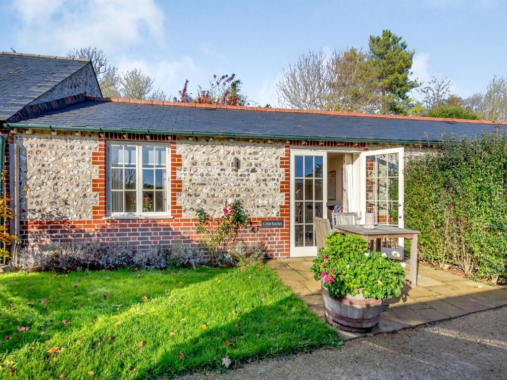 a small brick house with a table in a yard at Little Scarlett - Ukc6132 in Eastdean