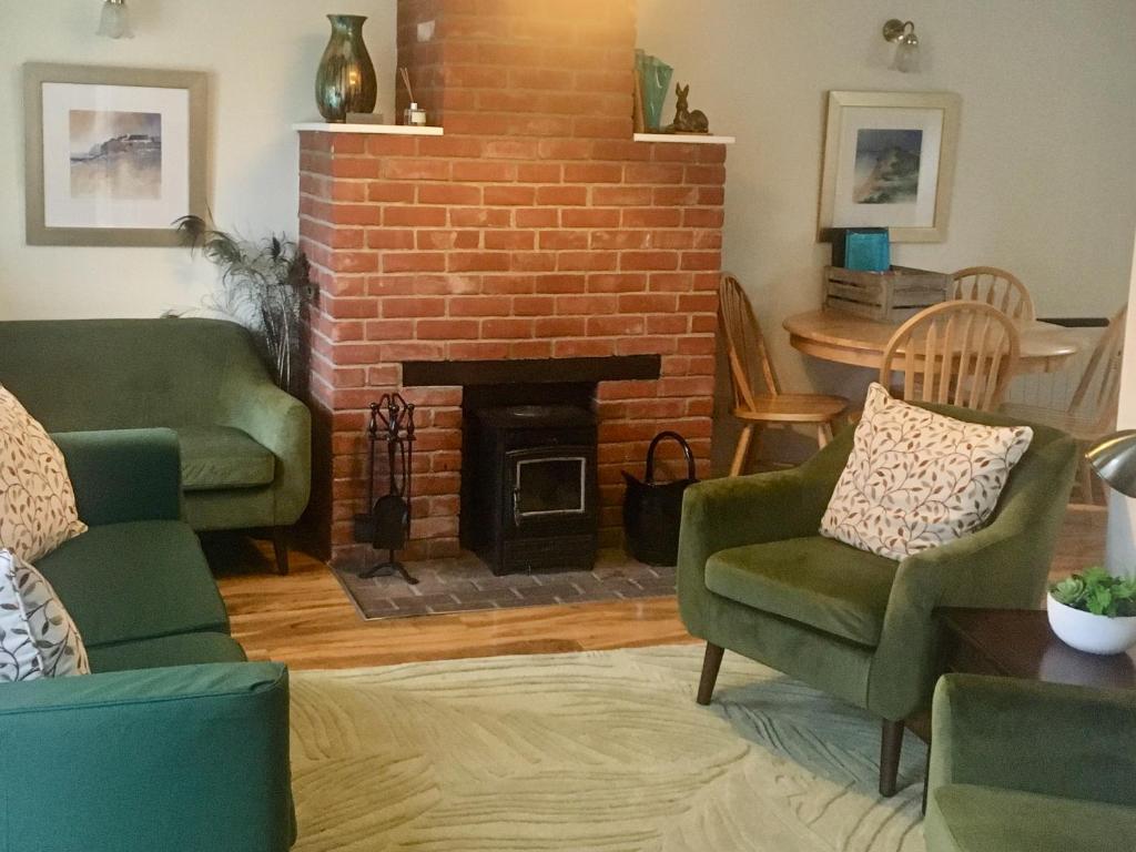 a living room with two chairs and a fireplace at Lark - Ukc6105 in Wootton Fitzpaine
