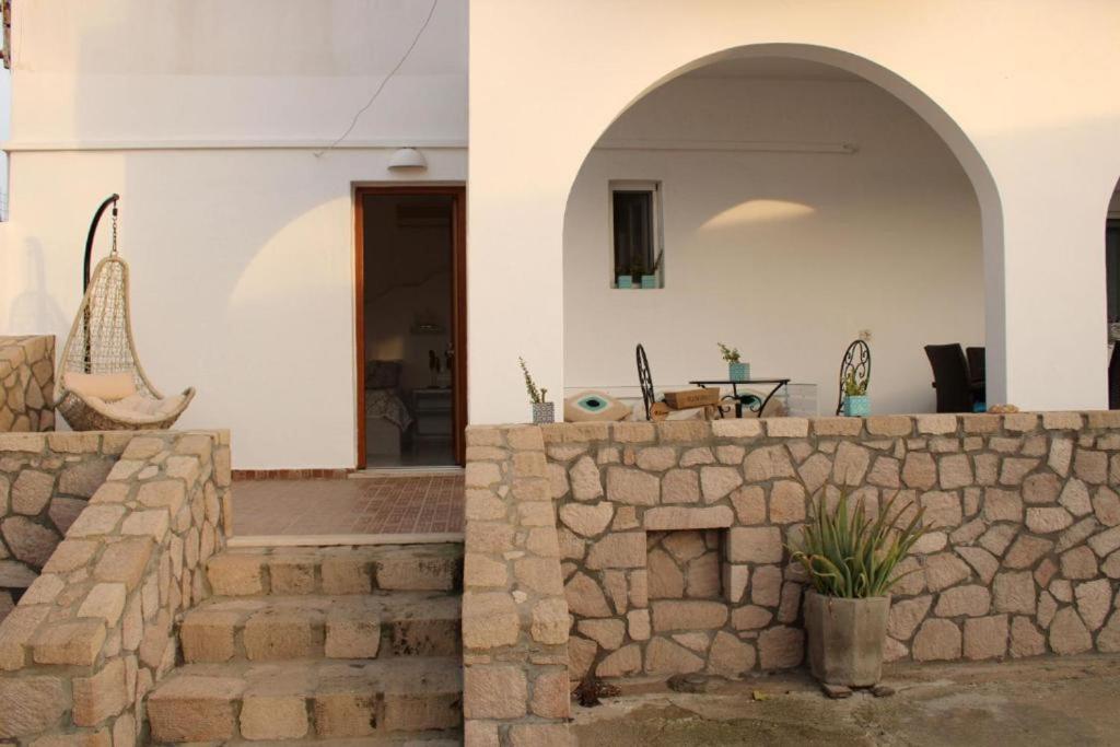 two images of a house with a stone wall at SunΚissed Suite - Pollonia Milos in Pollonia