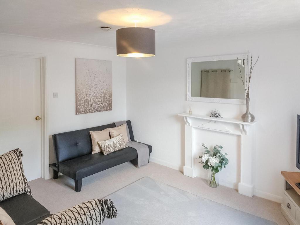 a living room with a chair and a mirror at Redcot Gardens in Stamford