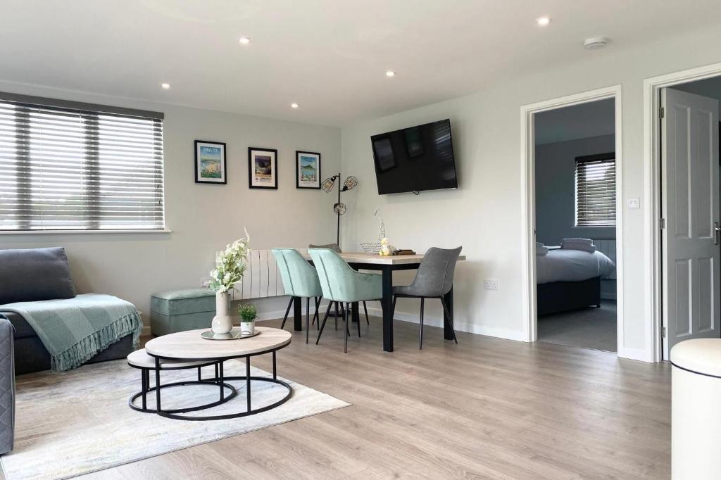 a living room with a couch and a table at Holywell - Cwc in Perranporth