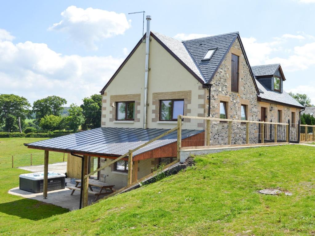 a house with a solar roof on top of a field at The Farmhouse - Ukc6250 in Linlithgow