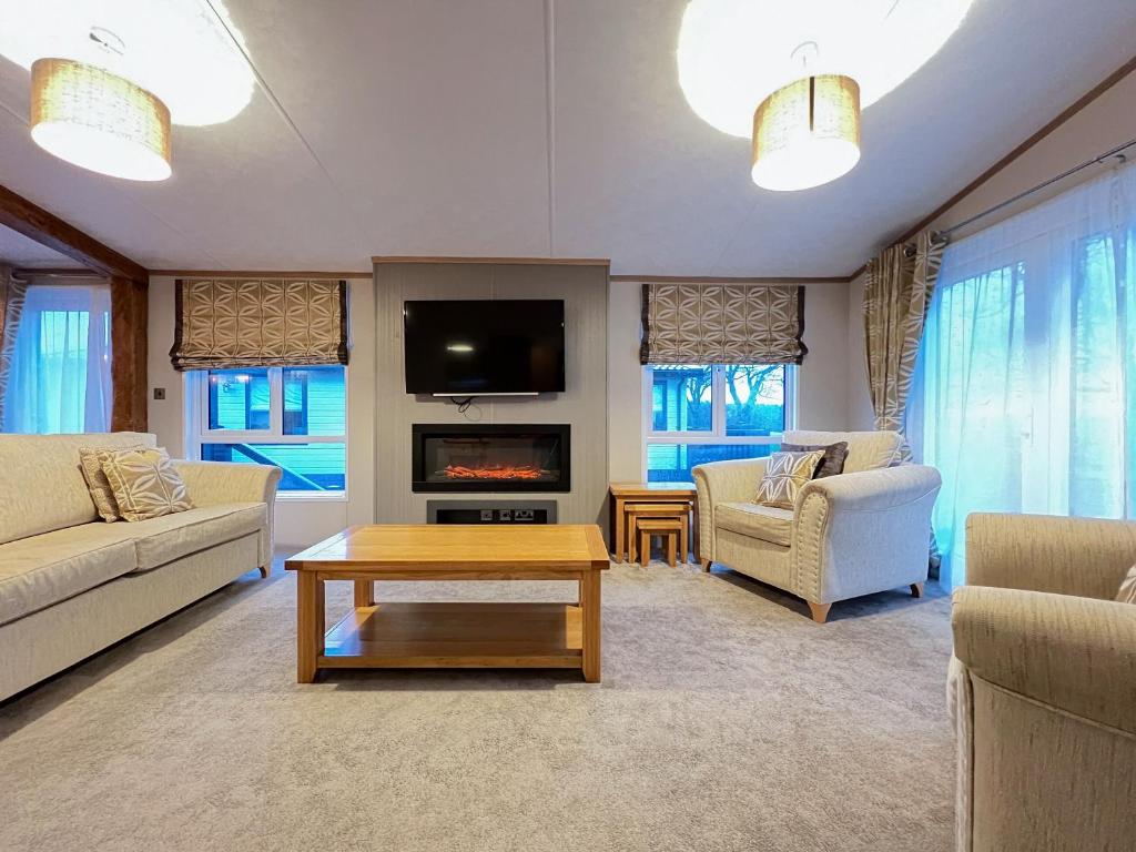 a living room with a couch and a tv at Saltire 26 in St. Andrews